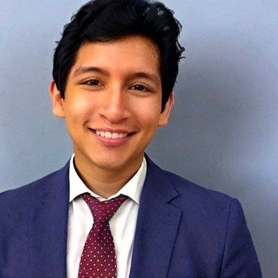 A portrait of myself, Edgar San Martin, Jr. Peruvian, tan skin, wavy hair in a blue suit.