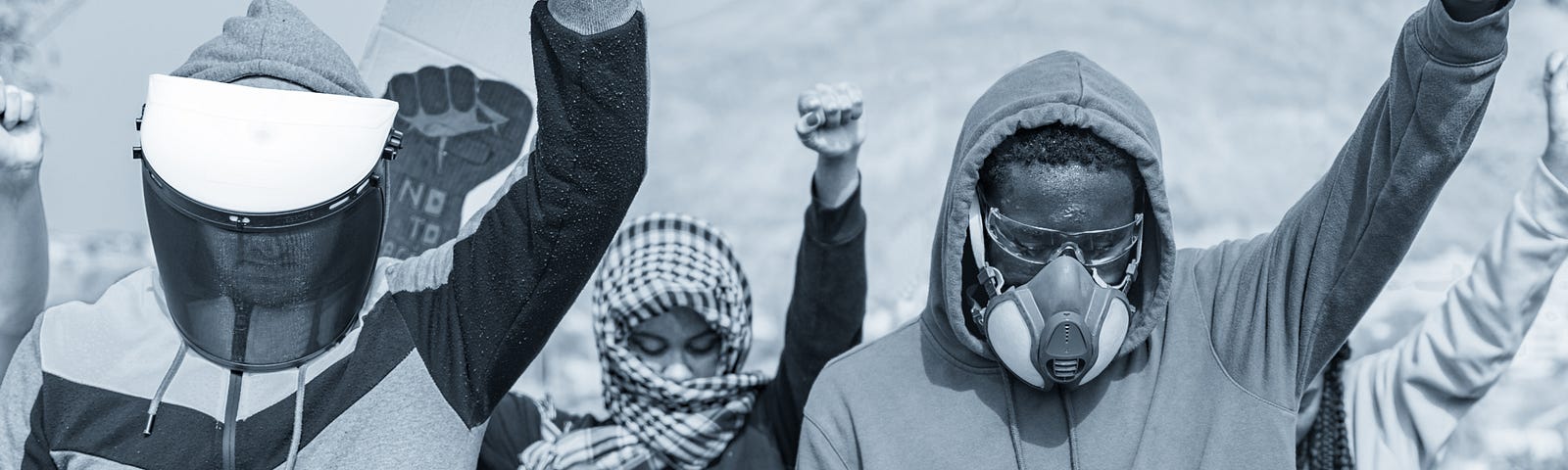 Monochrome image of activists raising fists as they protest.
