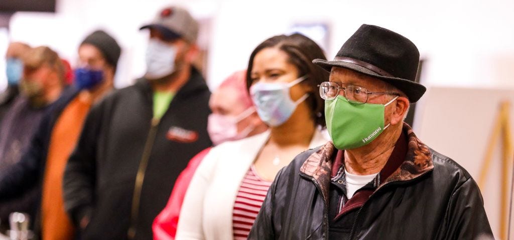 Voters wearing face masks in line at the polls.