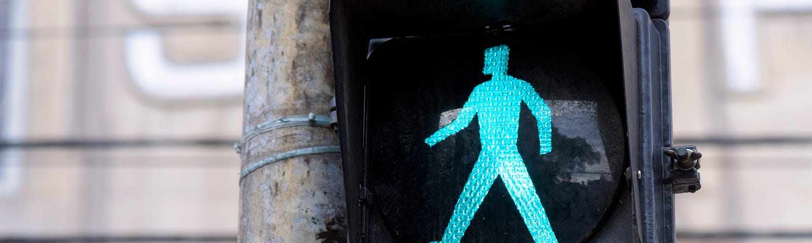 Green light walking sign on a street pole.