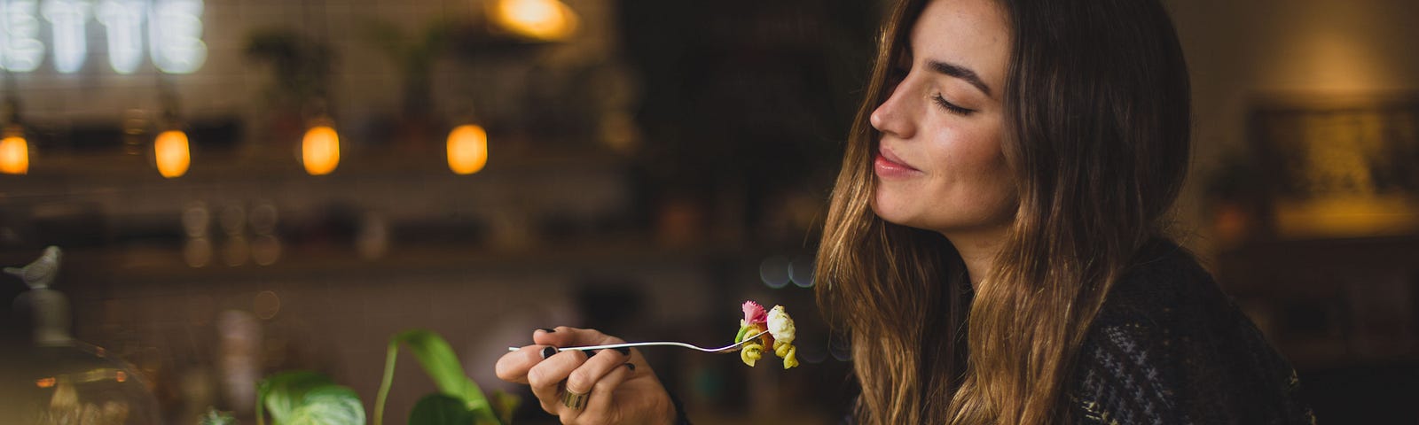 Pretty girl thoroughly enjoying the beautiful food in front of her, with inspiring ingredients all around.