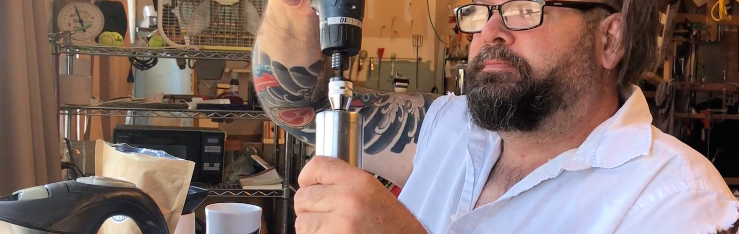 Guy using a drill to grind coffee.