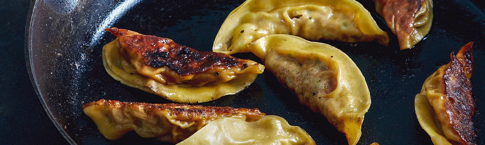 Pot Stickers in a cast-iron pan.