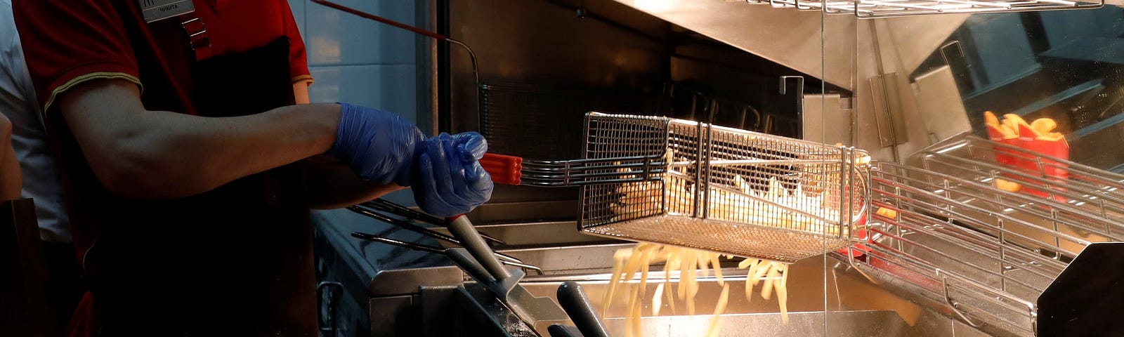 A McDonald’s worker cooking up some fries.