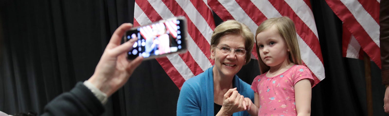 Sen. Elizabeth Warren poses for a photo with a young girl ahead of her Super Tuesday night event on March 3, 2020 in Detroit.