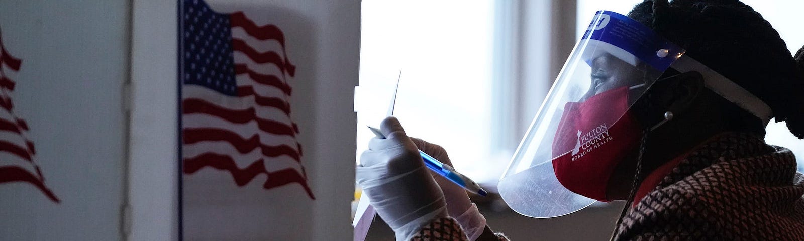 A poll worker talks to a voter before they vote on a paper ballot on Election Day in Atlanta on Tuesday, Nov. 3, 2020.