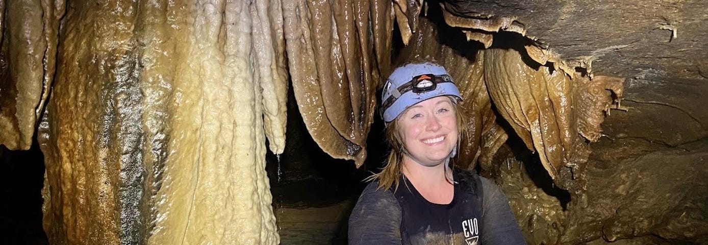 Kris Budd, FWS Scholar and Biologist with the USFWS Ecological Services in the Missouri Field Office smiling big in a cavern.