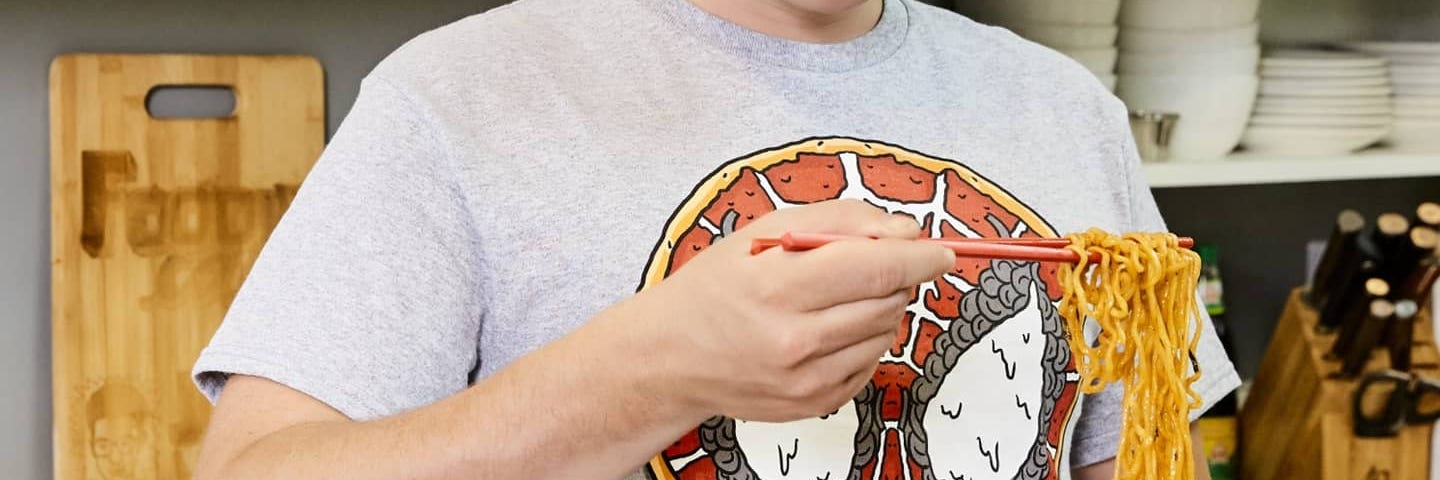 Photo of Justin Warner eating a bowl of noodles.