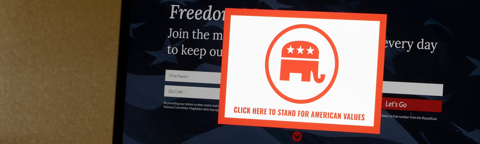 Red Republican elephant sticker reading “Click here to stand for American Values” on pasted on blackboard.