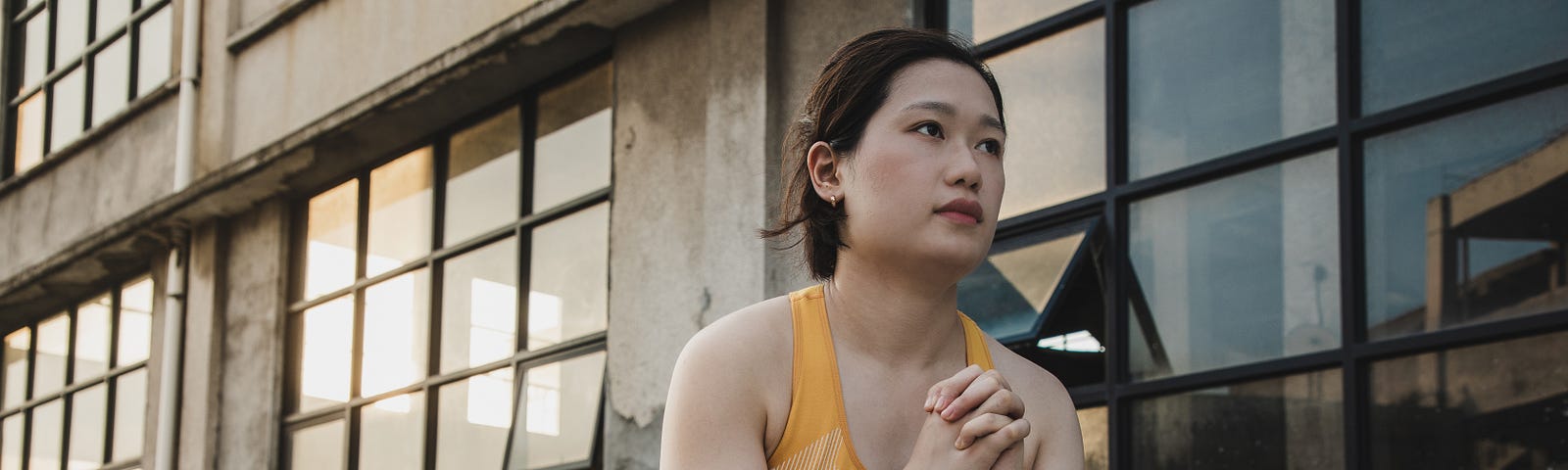 A young, Asian woman performing a squat exercise with a resistance band