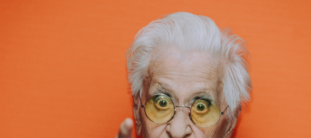 Image of older lady pointing at camera.