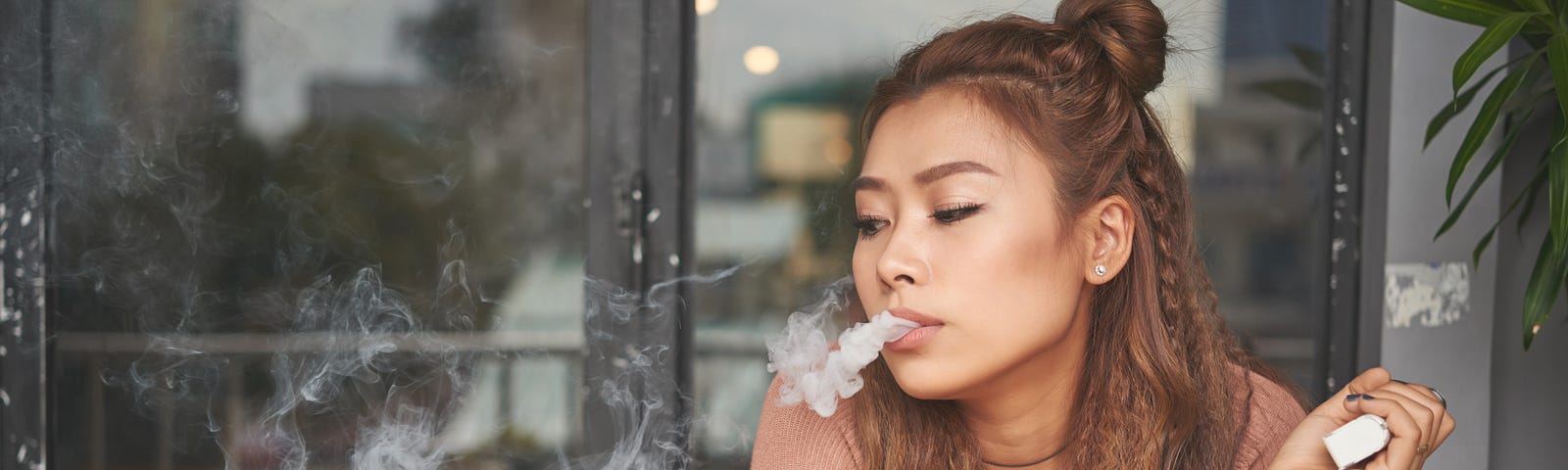 A young woman smoking an electronic cigarette.