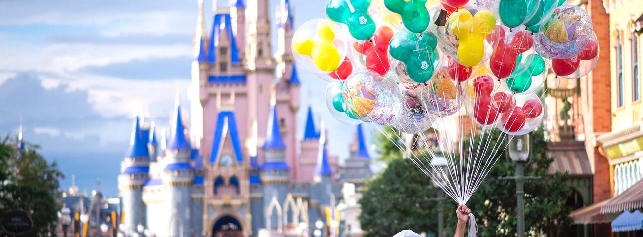A Disney employee sells balloons at Disney World’s Magic Kingdom.