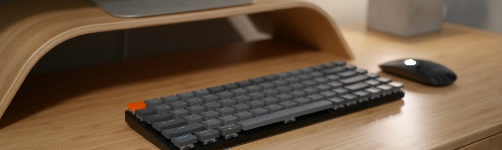 photo of the keychron k3 and a magic mouse on a bamboo desk
