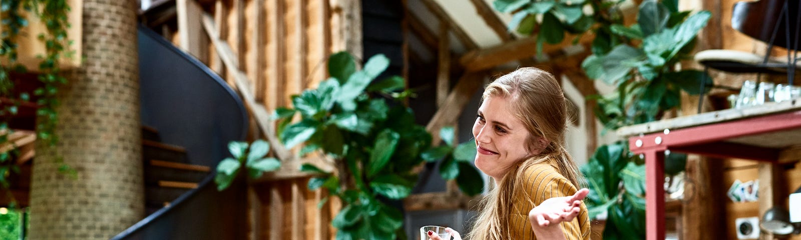 A woman is standing at a party and smiles while struggling and everybody else claps for her.