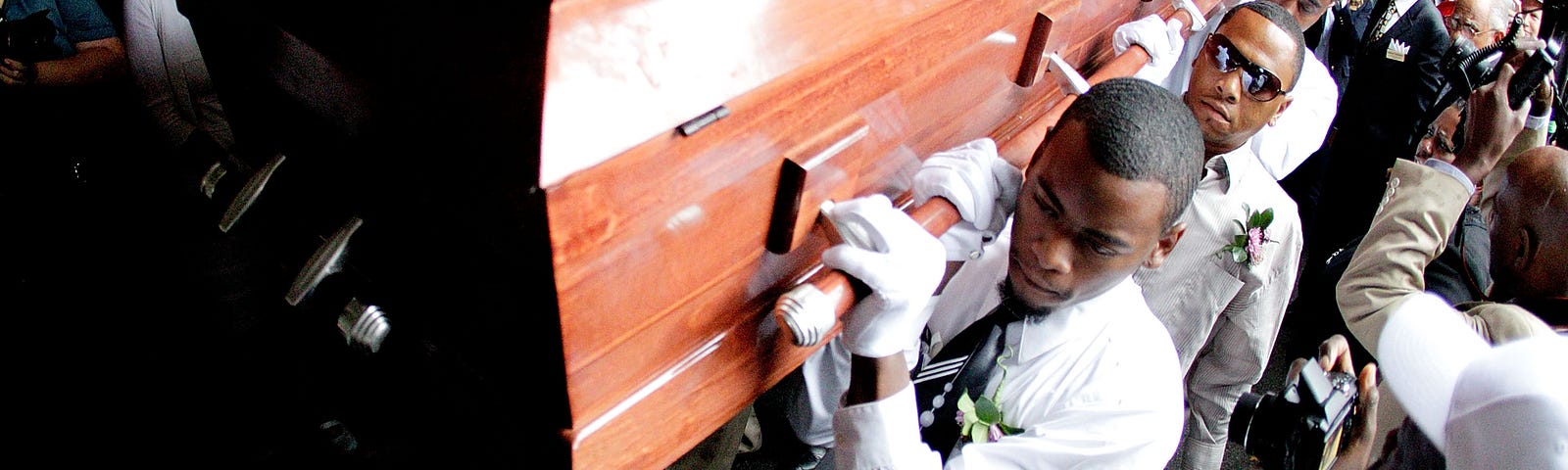 A photo of pallbearers carrying a casket at a homegoing in 2012.