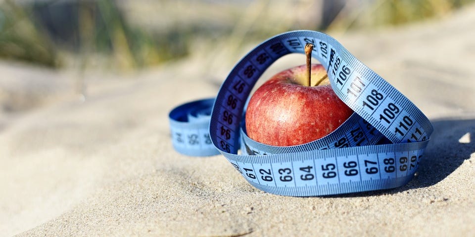 A tape measure is wrapped around an apple. #dieting #bodyimage #weightloss #weightgain #diet #loseweight #weight #apple