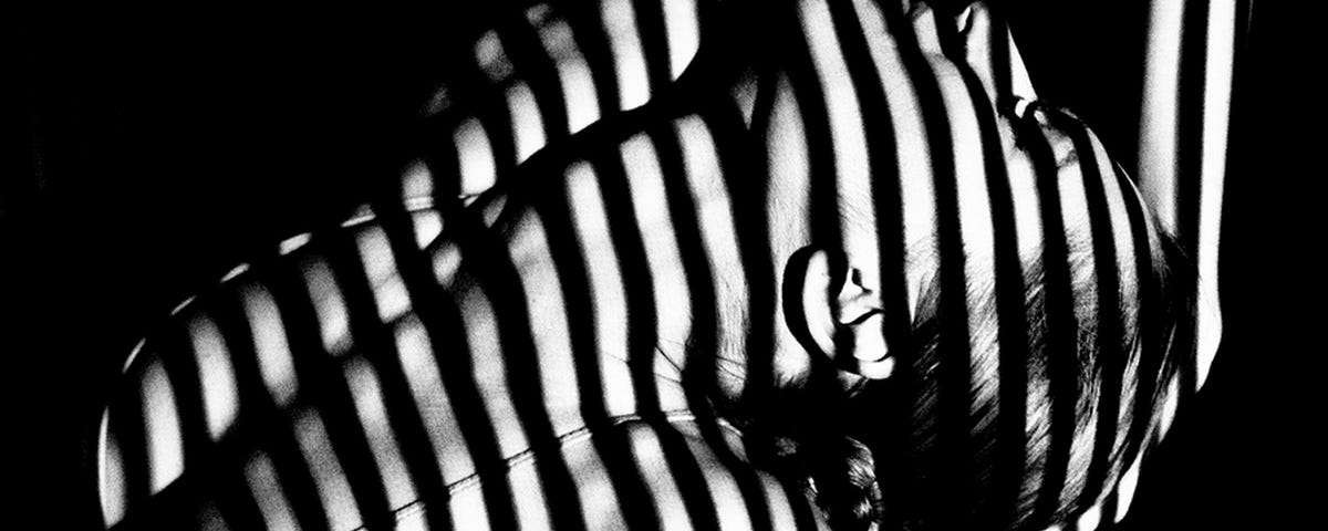 Photo by Aleksandar Pasaric on Pexels — a woman with stripes caused by shadows