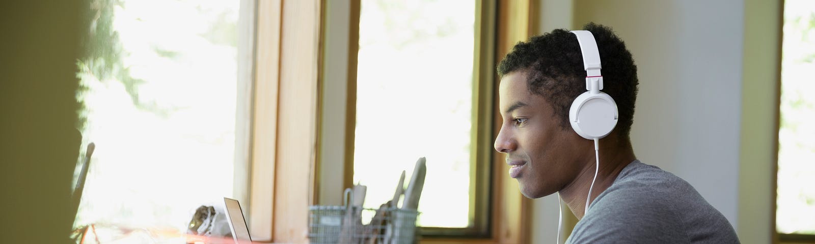 A man works on his laptop while listening to music.