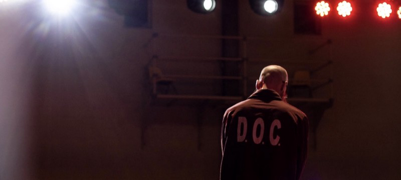 A photo of the back of a man wearing a collared long sleeve shirt that says “D.O.C.”