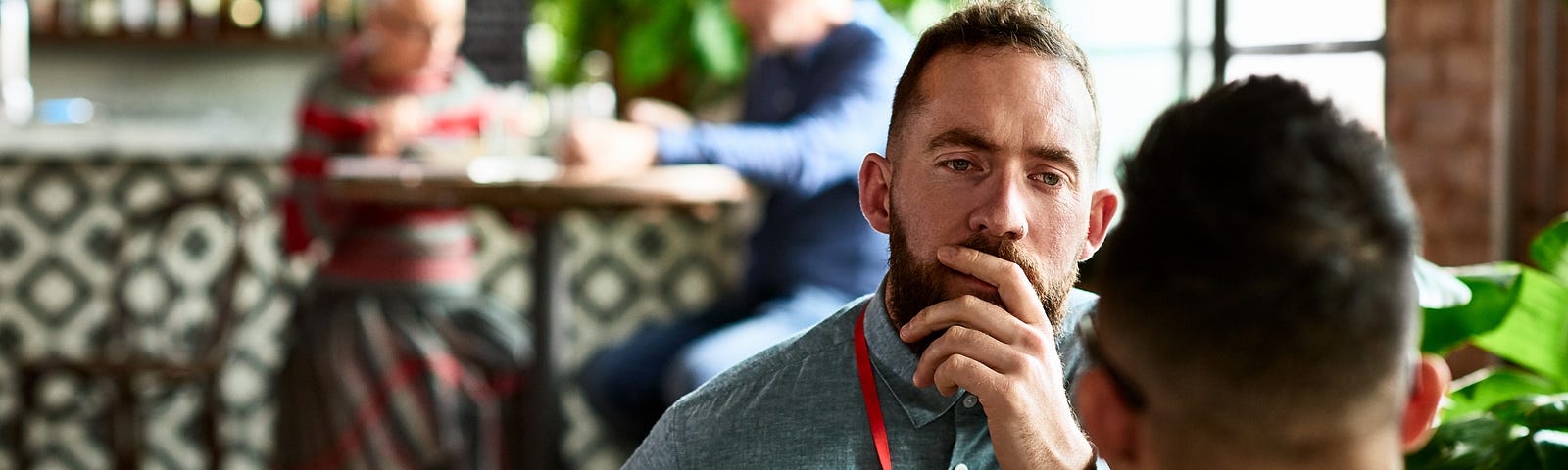 Man listening thoughtfully to business colleague in restaurant.