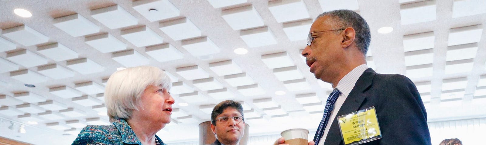 Federal Reserve Chair Janet Yellen (left) greets Howard University Economics Professor William Spriggs (right).