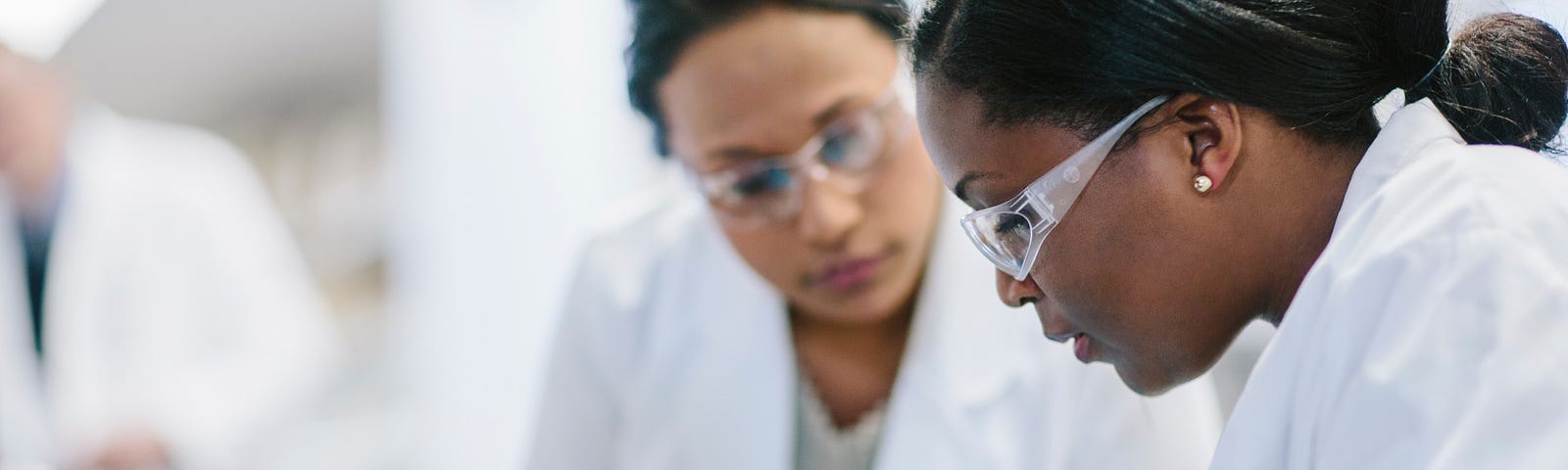 Female doctors examining petri dish in laboratory