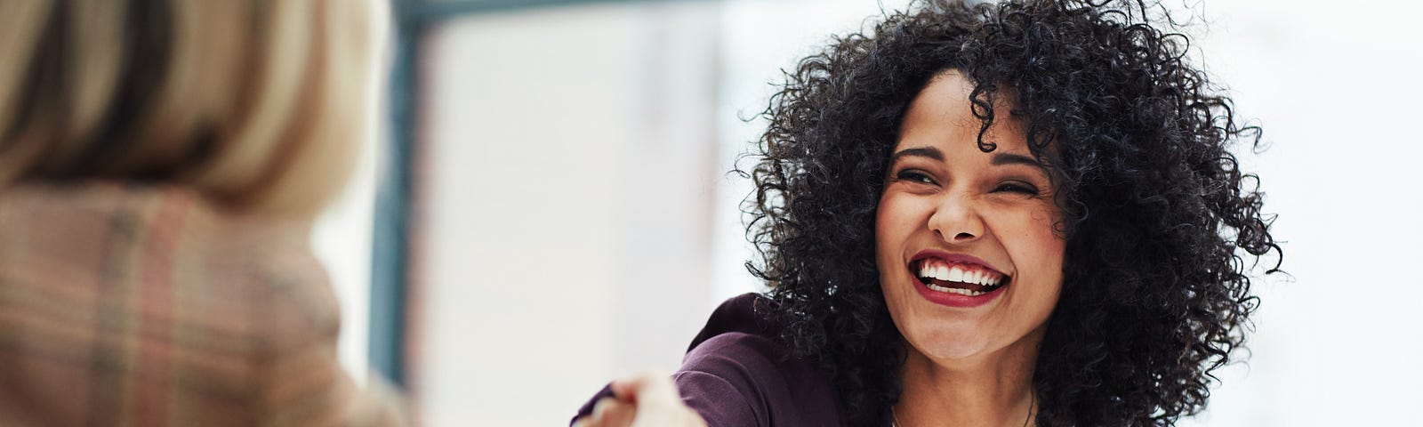 A female job candidate shakes her interviewer’s hand.