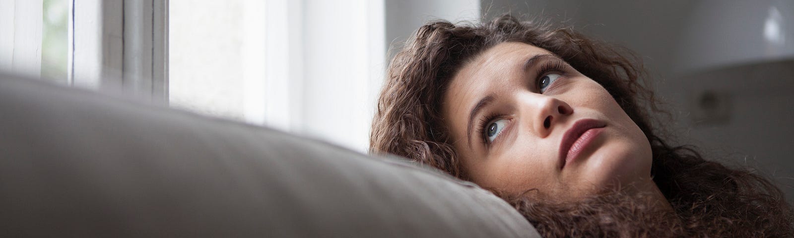 A photo of an annoyed woman looking out the window.