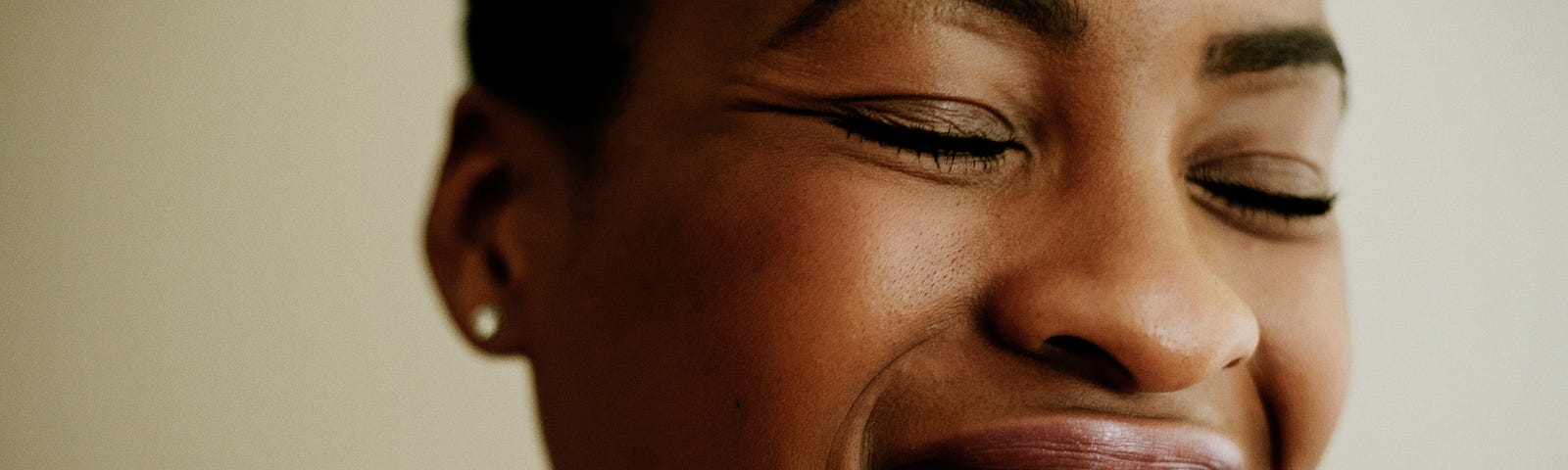 A closeup of a black woman smiling/laughing widely.