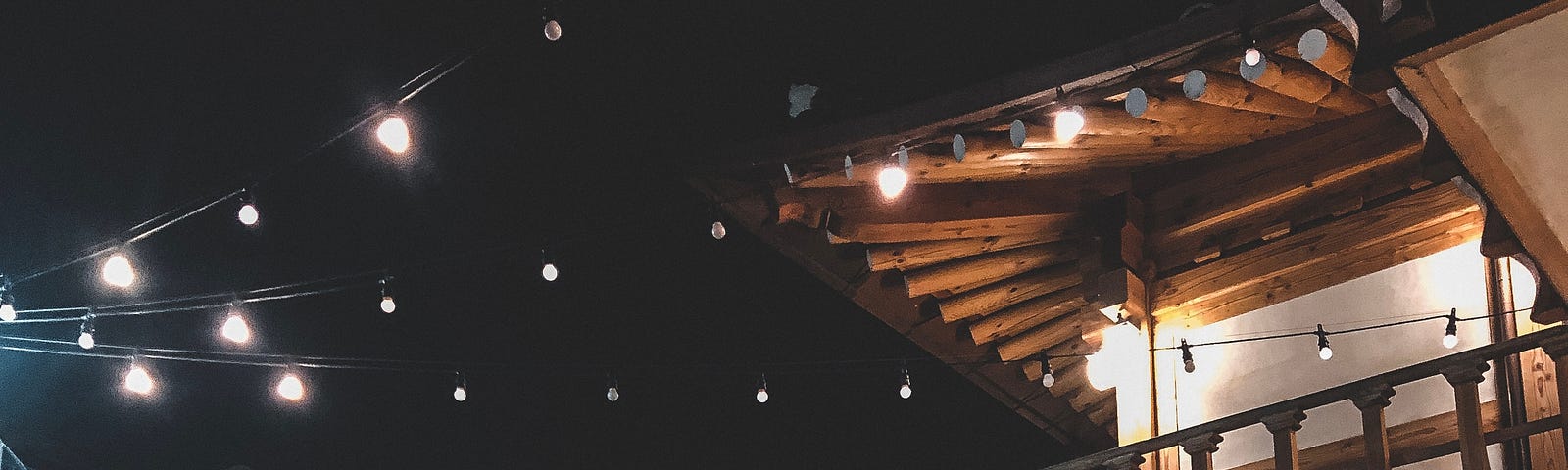 Korean hanok (한옥) courtyard lit by string lights at night.