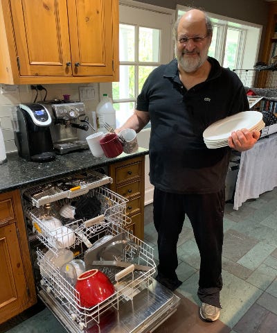 Stuart Diamond poses in front of a full dishwasher.