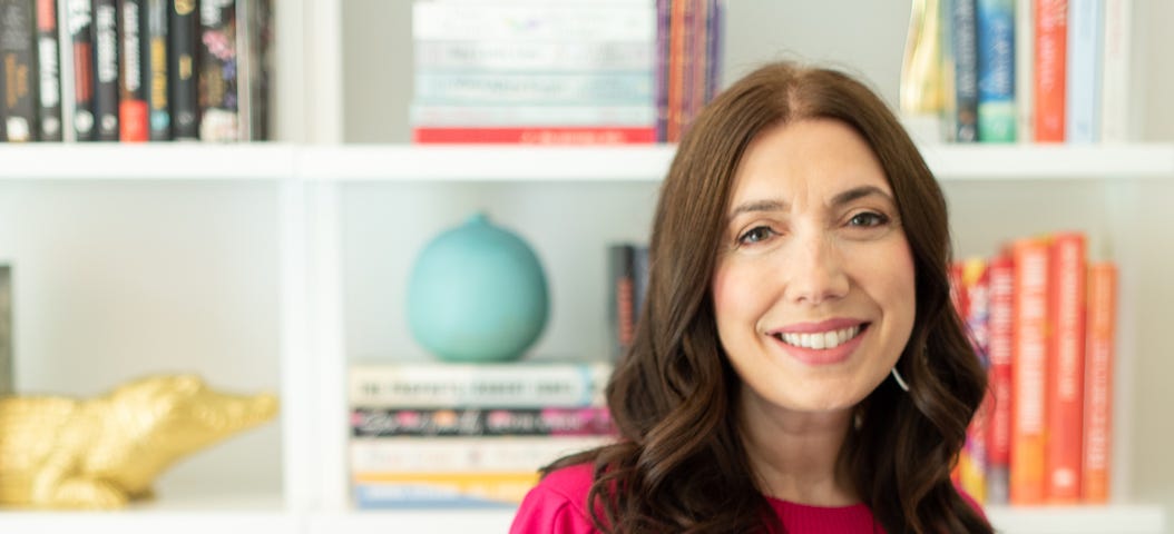 A photograph of author, investor and keynote speaker Fran Hauser standing in front of a bookcase.