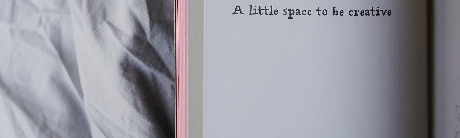 Photo of an open blank journal with text reading, “A little space to be creative”