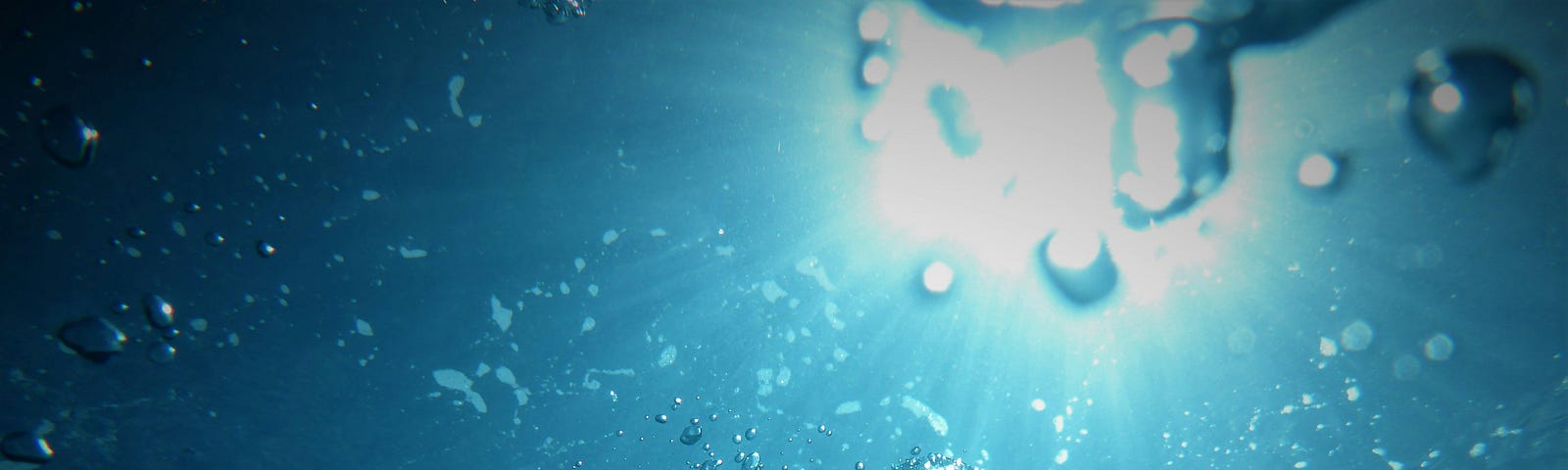 Sunlight viewed from underwater through bubbles.