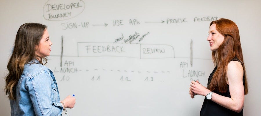 Women talking near a whiteboard