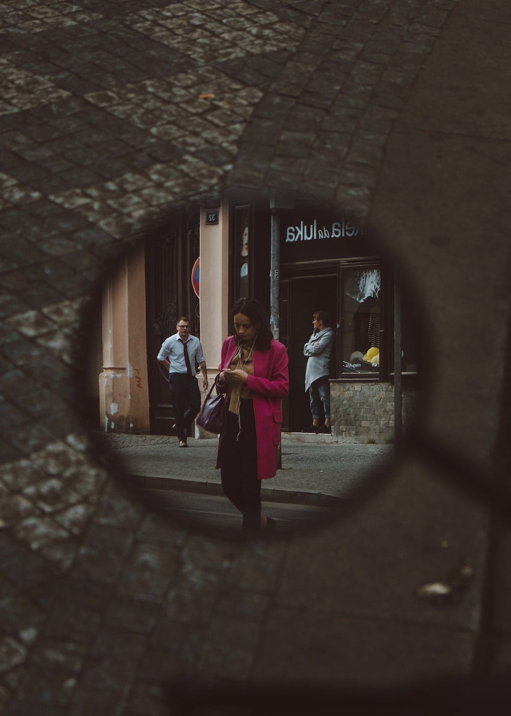 Uma mulher sendo vista usando smartphone pelo retrovisor de uma moto, em meio a rua