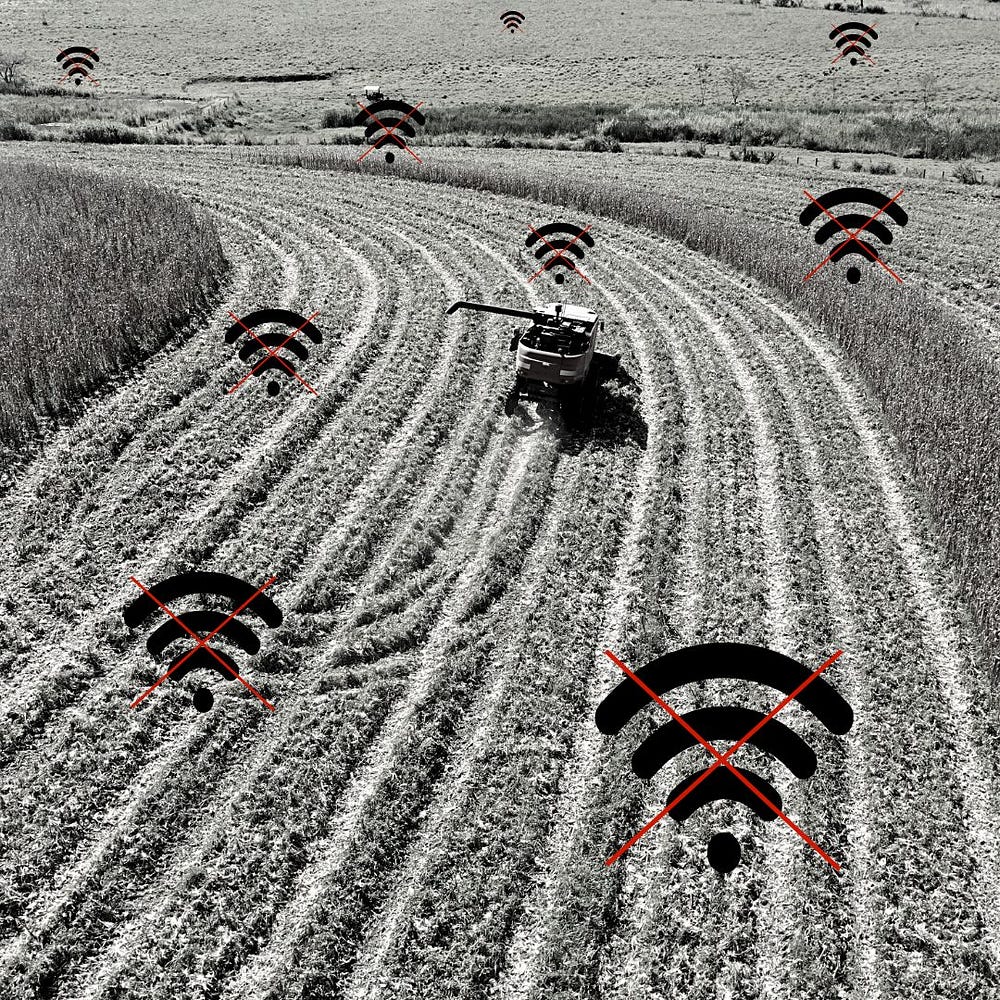 Imagem em preto e branco mostra uma colheitadeira em uma extensa área de plantação de milho sem sinal de rede, representados pelo símbolo do wifi com um x sobre ele.