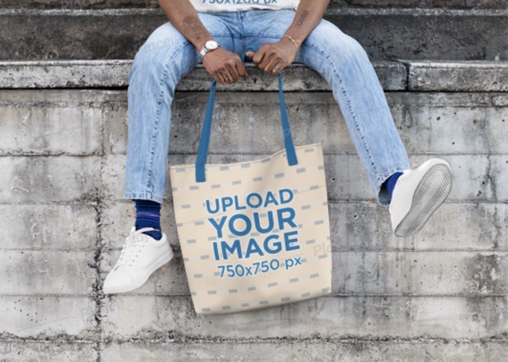 T-Shirt and canvas bag mockup featuring a man sitting in front of a brick wall