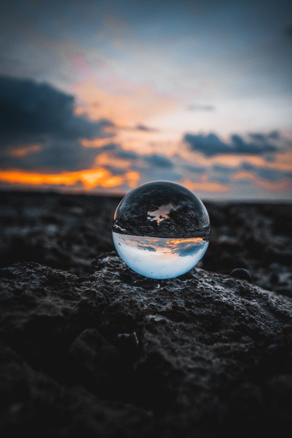 A droplet balancing on the rocky ground of a mountain