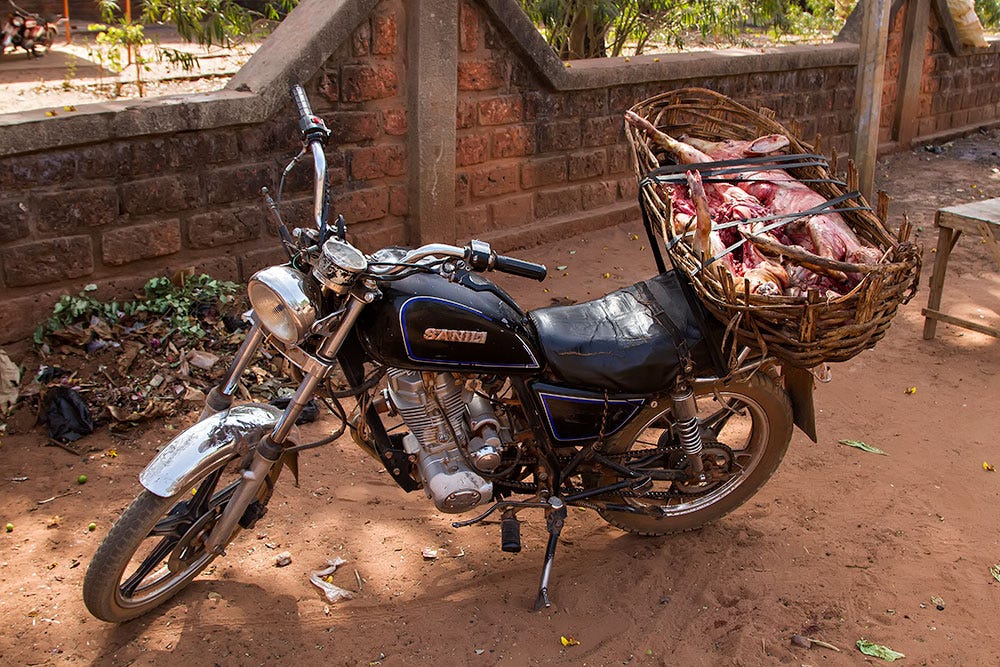 Transporte de cerdos muertos en moto en Orodara, Burkina Faso.