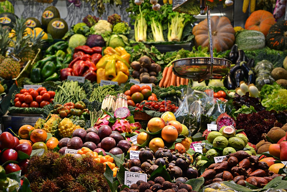 A collection of assorted fruits and vegetables in a produce aisle.