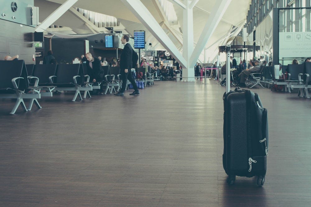 A suitcase standing alone in the middle of an airport