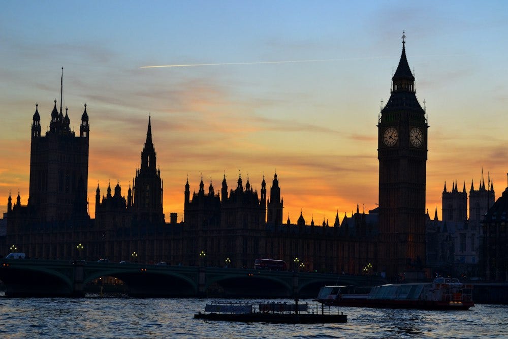 Houses of Parliament in shadow with bright sunset behind
