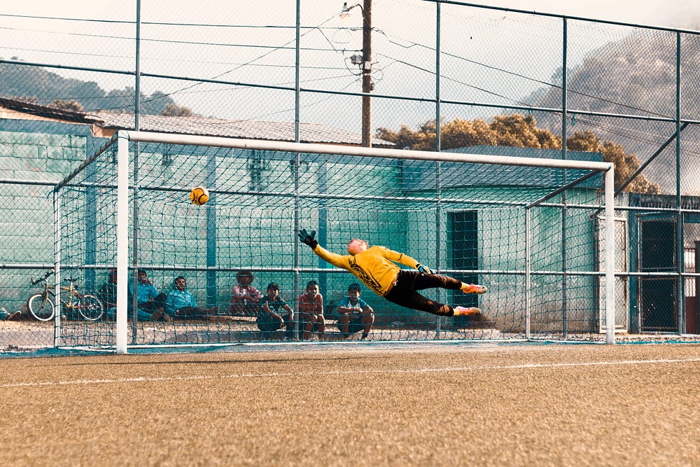 Football goal keeper trying to block the goal