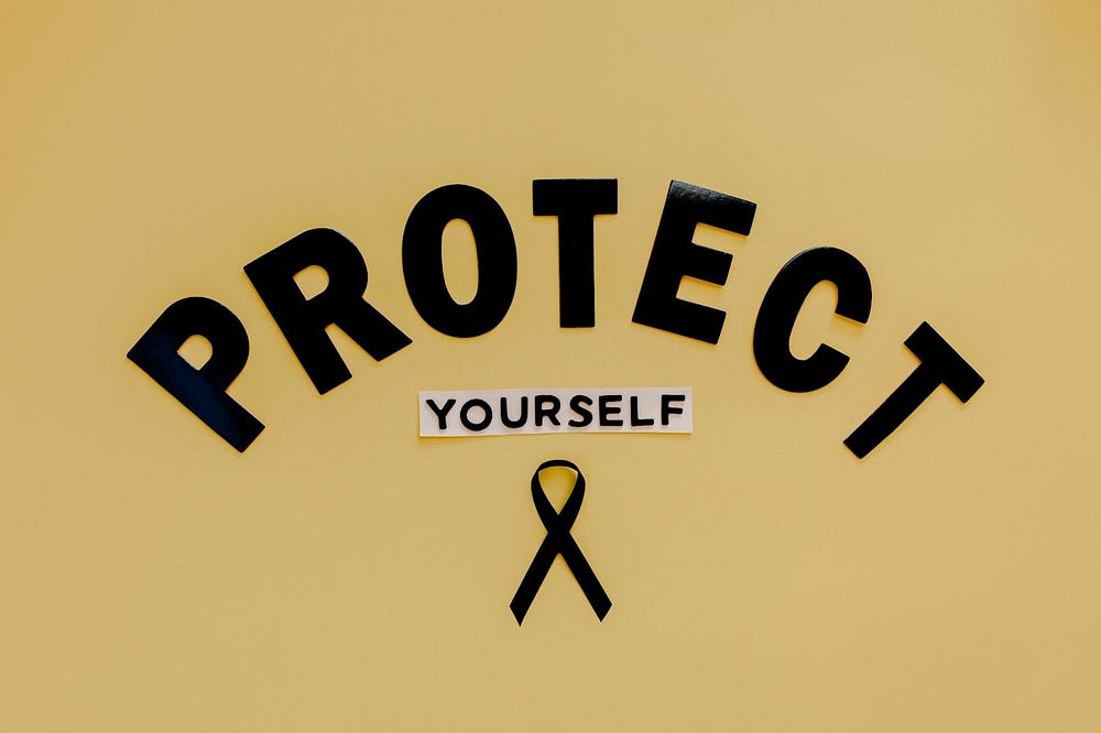 Yellow background with Protect Yourself in black lettering. The lettering is box lettering. Protect is laid out as an arch with yourself is about a fourth of the size on a white background centered under protect. Beneath both is a black melanoma ribbon.