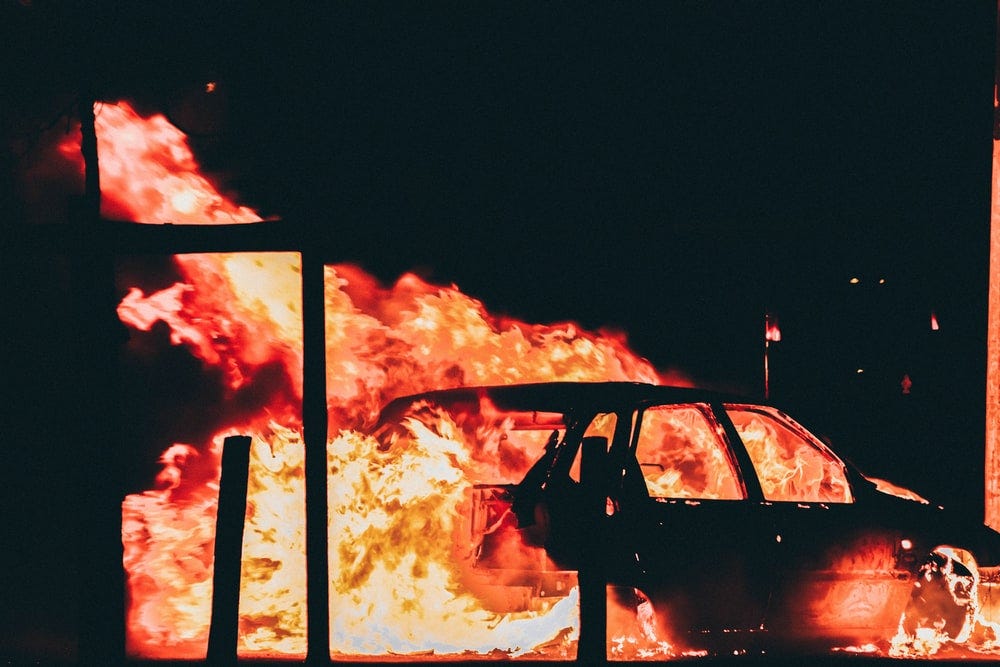 A car is engulfed in flames. Image by Florian Olivo.