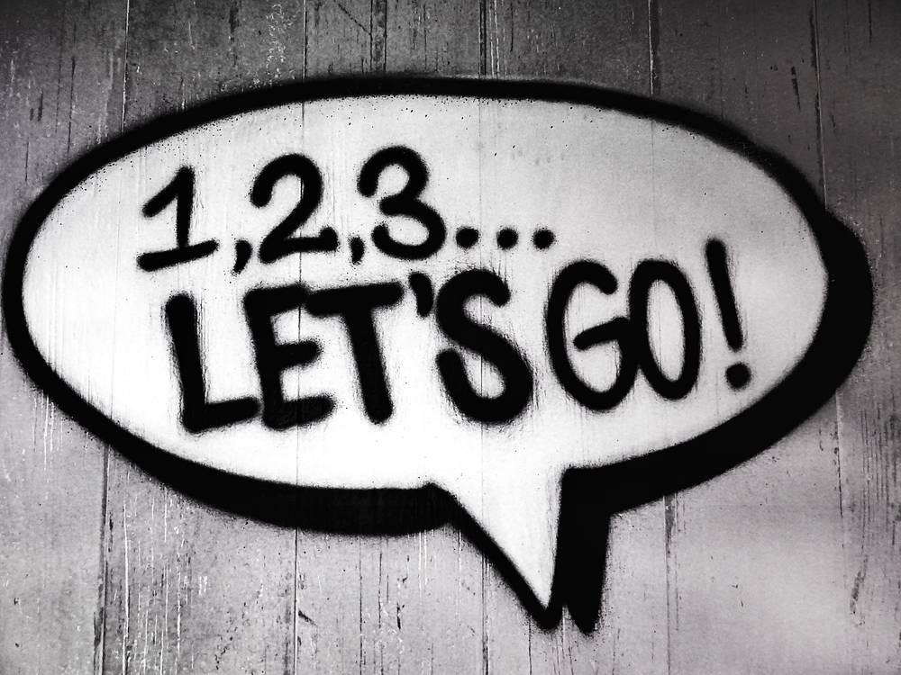 A spray painted speech bubble saying “1, 2, 3.. let’s go!”