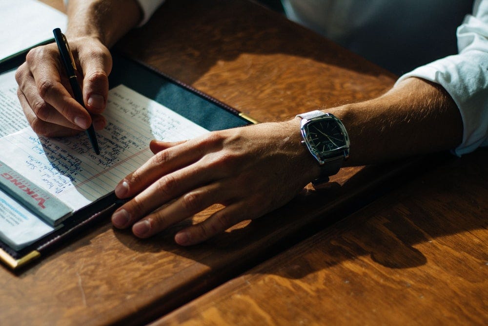 A men writing a pitch on paper.