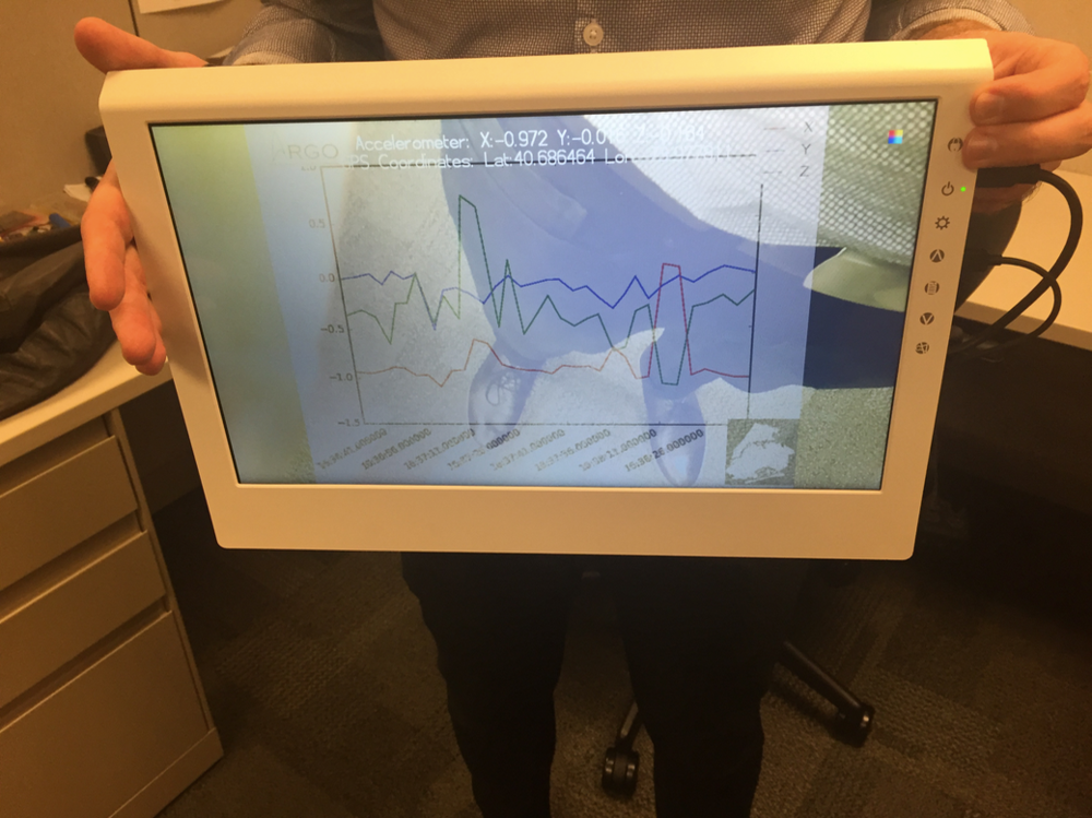 The LCD screen displaying a live video feed overlaid with a graph of accelerometer readings and annotations